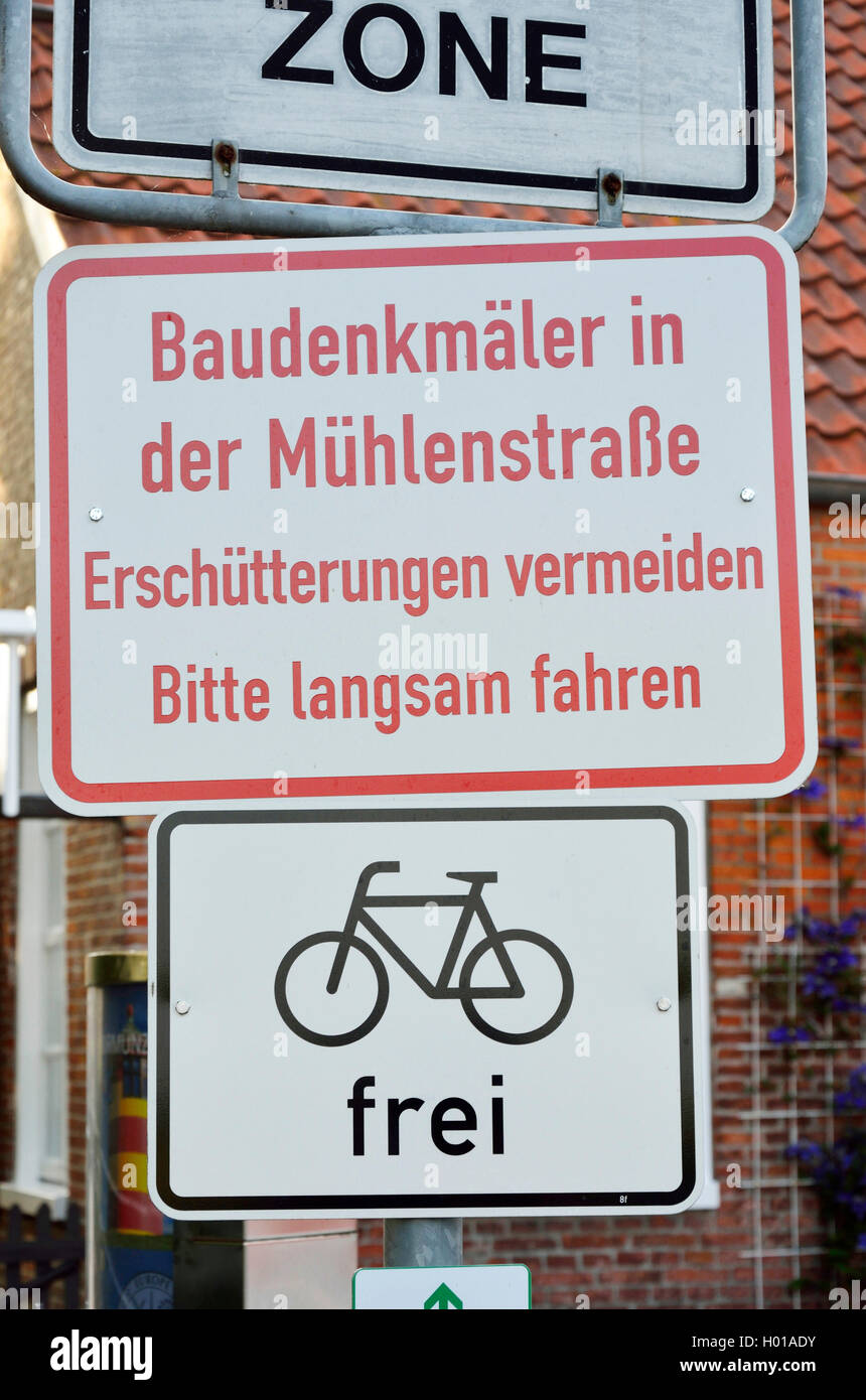 warning sign `historic buildings, avoiding tremors┤, information sign `free for cyclists┤, Germany, Lower Saxony, East Frisia, Greetsiel Stock Photo